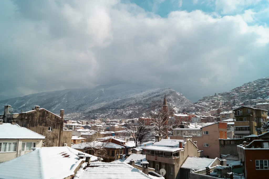 بيوت مدينة بورصة القديمة والثلج يغطي الأسطح وجبل أولوداغ في الخلفية